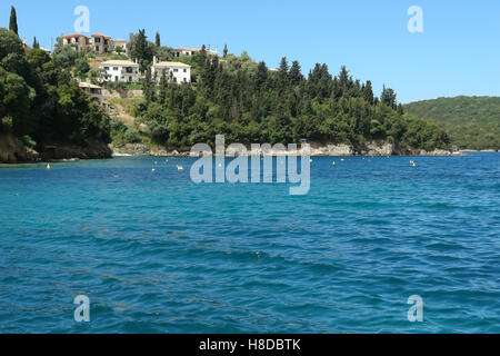 Sivota, GREECE, May 09, 2013: Landscape with green island, mountain, buildings and emerald bay in Ionian sea, Greece. Stock Photo