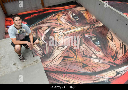 Hong Kong, Hong Kong S.A.R, China. 10th Nov, 2016. Rooftop painting by Parisian street artist Alexandre Monteiro aka Hopare (pictured)of Masai warrior Daniel Ole Sambu, .Street art in Hong Kong ahead of the The 'Hope for Wildlife' Gala Dinner painted to raise awareness for the plight of endangered animals the world over.Sheung Wan Hong Kong.10th November 2016. Photo by Jayne Russell. © Jayne Russell/ZUMA Wire/Alamy Live News Stock Photo