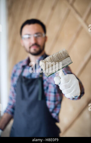 young painter man with tin of painting and brush showing thumbs up Stock Photo