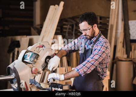 Framing contractor using a circular cut off saw to trim wood studs length. Stock Photo