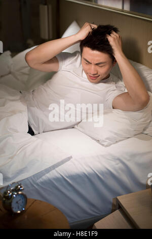 Young Chinese man suffering from insomnia Stock Photo