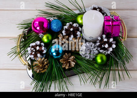 Christmas multicolored ornaments and candle centerpiece. Christmas decoration with pine cones. Christmas greeting background. Stock Photo