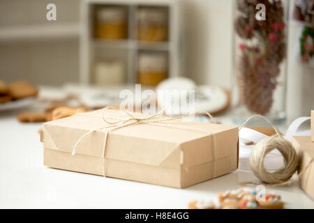 Cardboard box, postal parcel wrapped in brown kraft paper tied Stock Photo