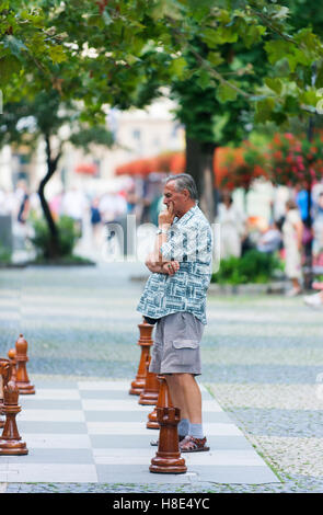 Chess player contemplates his next move in Bratislava's Hviezdoslav Square. Stock Photo