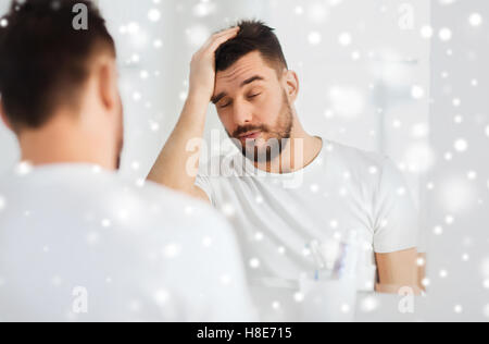 sleepy young man in front of mirror at bathroom Stock Photo