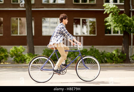 young hipster man with bag riding fixed gear bike Stock Photo