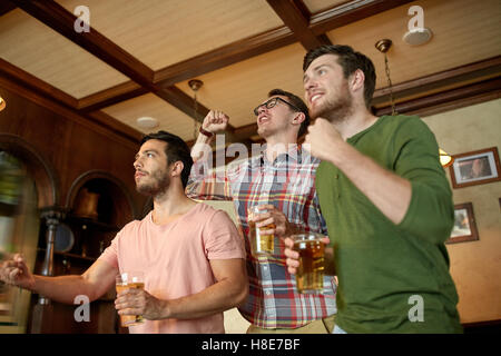 friends with beer watching sport at bar or pub Stock Photo
