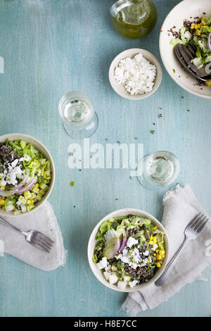 Roasted Poblano Quinoa Salad served with queso fresco, cilantro dressing. Photographed on a light blue/green background from top Stock Photo