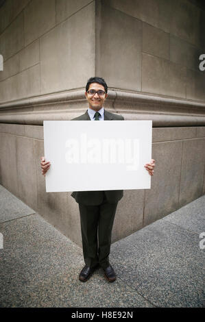 Businessman holding blank sign Stock Photo