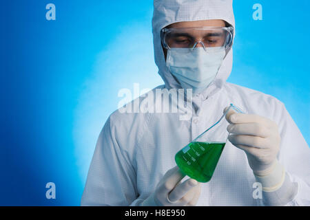 an in a clean-room suit holding a medical flask Stock Photo