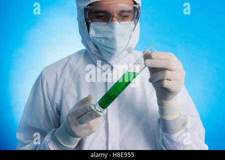 an in a clean-room suit holding a medical flask Stock Photo