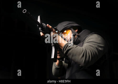 A man with a gun wearing a bulletproof vest and helmet. Antiterrorist. Stock Photo