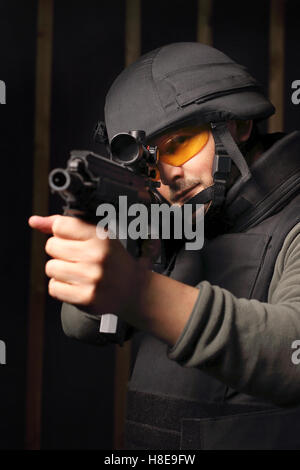 Military. A man with a gun wearing a bulletproof vest and helmet. Stock Photo