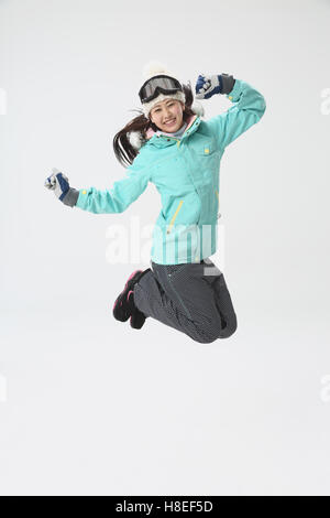 Young Japanese woman wearing snowboard wear on white background Stock Photo