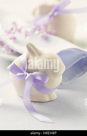 Two funny easter bunny on blue pastel background. Easter table setting Stock Photo