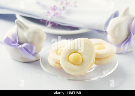 Homemade easter cookies and funny easter bunny on blue pastel background. Easter table setting Stock Photo