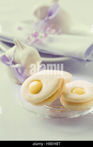 Homemade easter cookies and funny easter bunny on blue pastel background. Easter table setting Stock Photo