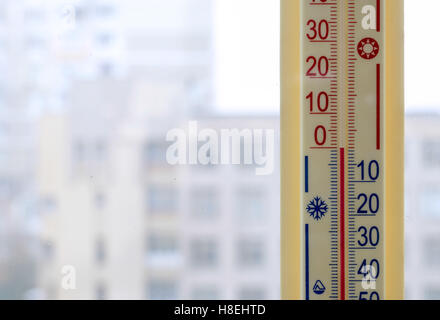 A thermometer, fixed out of the window, shows that it is zero degree celsius outdoor, while it is warm inside the room Stock Photo