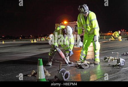 Engineers replace landing lights during the overnight refurbishment of the South runway at London's Heathrow Airport Stock Photo