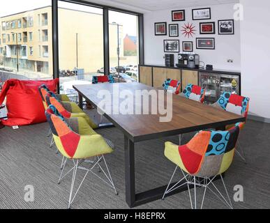 Trendy meeting room in the new Ibis Hotel in Cambridge, UK. Shows multi-coloured fabric chairs, large bean-bag, coffee machine Stock Photo