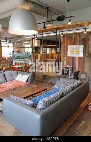 Lounge and reception area in a new Ibis Hotel in Cambridge, UK. Shows vintage style sofas, tables and shelves Stock Photo