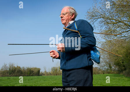 John Baker divining or dowsing for water in a field in Slimbridge, Gloucestershire, UK.a Stock Photo
