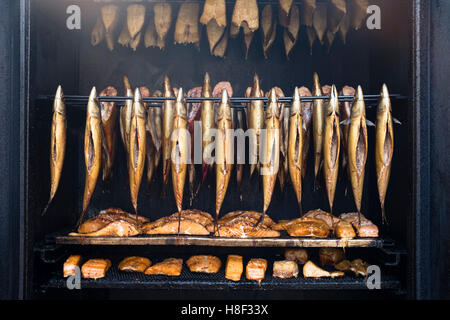 View of fish being smoked in mobile smokehouse at outdoor organic farmers market in Prenzlauer Berg in Berlin , Germany Stock Photo