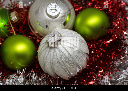 Variety of Christmas and New Years decoration on red and silver sparkly garland background Stock Photo