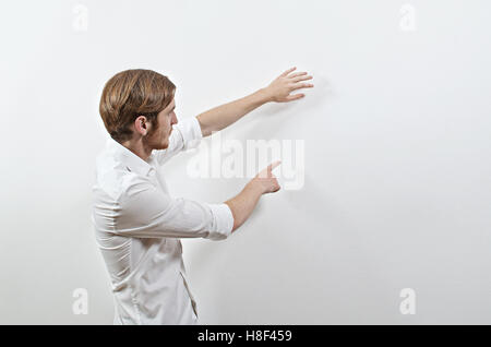 Young Adult Male Presenter in White Shirt Gesturing, Showing, Teaching Stock Photo