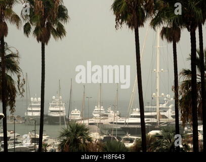 AJAXNETPHOTO. 2016. CANNES, FRANCE. - COTE D'AZUR RESORT - LOOKING ACROSS THE BAY OF CANNES THE MOUNTAINS ON THE FAR SIDE OBLITERATED BY A HEAVY RAIN-STORM WITH SUPER YACHTS AND MOTOR CRUISERS MOORED IN PORT PIERRE CANTO MARINA. PHOTO:JONATHAN EASTLAND/AJAX  REF:GX163110 6486 Stock Photo