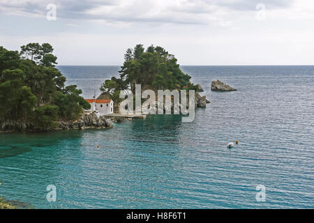 Parga, GREECE, May 09, 2013: Landscape with church and boat in bay of Parga town on the coast of Ionian sea, Greece. Stock Photo