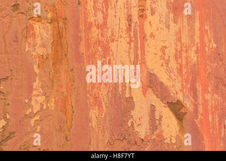 Abstract background texture of red and cream paint, and rust marks, on a sheet of metal. Stock Photo