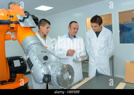 scientist and apprentices using machine for experiment Stock Photo