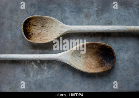Two old wooden spoons on a grey background Stock Photo