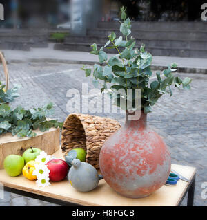 Autumn composition decorating the counter. Apples, quinces and lemons, together with eucalyptus and daisies on the table Stock Photo