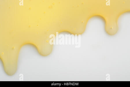 Honey liqiud flowing down on white background Stock Photo