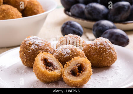 plum dumplings on white plate with sugar icing Stock Photo