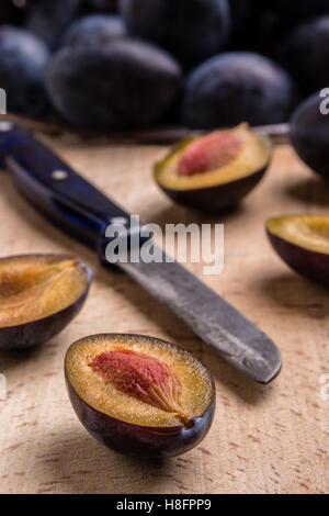 fresh organic tasty plums on cutting board with knife Stock Photo