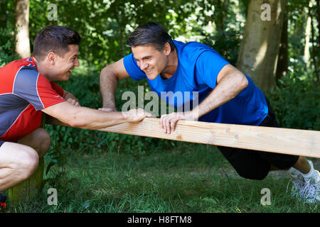 Mature Man Exercising With Personal Trainer In Park Stock Photo