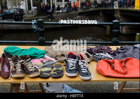 Personal items for sale on a table on the street in Amsterdam during the King's birthday celebration, Holland, Netherlands. Stock Photo