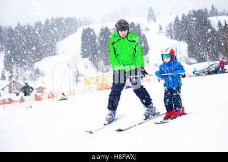 Happy little boy learning skiing with his father during winter holidays in Swiss Alps Stock Photo