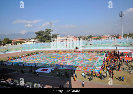 Kathmandu, Nepal. 11th November, 2016. Nepalese Buddhist Kora Arounds World's largest Thangka Painting of 12 important lifestyle of the Lord Gautam Buddha showcased at Dashrath Rangasala Stadium, Kathmandu, Nepal on Friday, November 11, 2016. The effort of more than 10,000 volunteers from over 16 countries, the thangka was finally completed in 2002. The painting representing 12 important lifestyle of the Lord Gautam Buddha. Credit:  PACIFIC PRESS/Alamy Live News Stock Photo