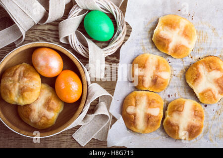 Homemade Easter hot cross buns and eggs on wooden table, top view Stock Photo
