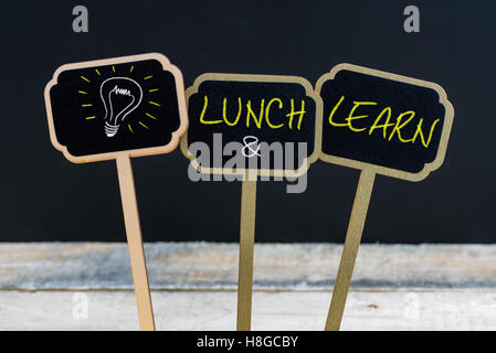 Concept message LUNCH and LEARN and light bulb as symbol for idea written with chalk on wooden mini blackboard labels Stock Photo