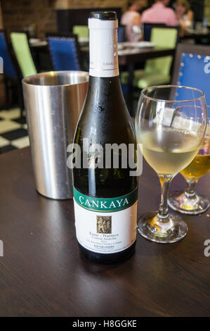 Transparent bottle of white dry wine on the table. White wine glass on ...