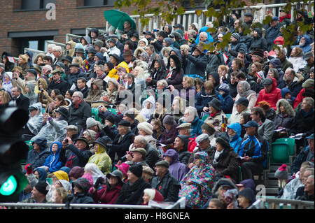 City of London, UK. 12th November, 2016. The world’s largest unrehearsed procession, The Lord Mayor’s Show, takes place through the City of London from the Guildhall to The Royal Courts of Justice on the Strand where Dr Andrew Parmley is sworn in on his first day in office. The ancient carnival is 801 years old this year and takes place in cold, wet weather in spite of which crowds line the route. Rain soaked spectators on an official stand. Credit:  Malcolm Park editorial/Alamy Live News. Stock Photo