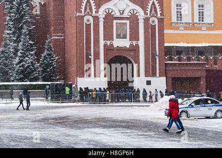 Moscow, Russia. Saturday, November 12, 2016. Early winter in Moscow. No sun, cloudy. Light frost up to -5 degrees Centigrade (+23F) by the evening, steady snowfall, but not very heavy one. Unidentified people in line by the Nikolskaya (St. Nicholas) tower of the Kremlin to visit a burial plase of the Soviet leaders and prominent people like Yury Gagarin by and inside the Kremlin wall. Credit:  Alex's Pictures/Alamy Live News Stock Photo