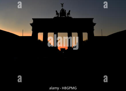 Berlin, Germany. 12th Nov, 2016. The sun sets behind the silhouetted Brandenburg Gate in Berlin, Germany, 12 November 2016. Photo: Ralf Kirschberger/dpa/Alamy Live News Stock Photo
