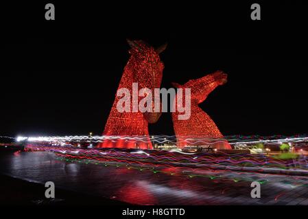 Falkirk, Scotland, UK. 12th November, 2016 Light trails from runners at the Supernova 5k fun run where runners are asked to wear glowing colours with the Kelpies lit in red for remembrance day. Stock Photo