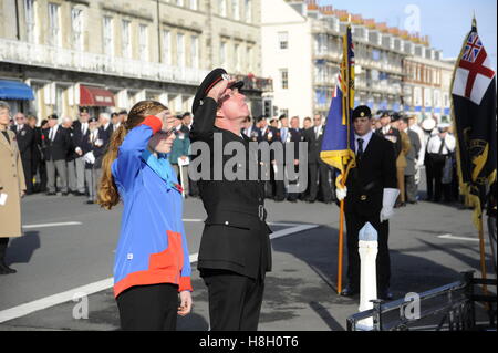 Weymouth, Dorset, UK. 13th November 2016. A fire officer salutes the memorial after laying a wreath during the Remembrance Sunday service and parade at the Weymouth War Memorial on the Esplanade in Dorset.   Photo by Graham Hunt/Alamy Live News Stock Photo